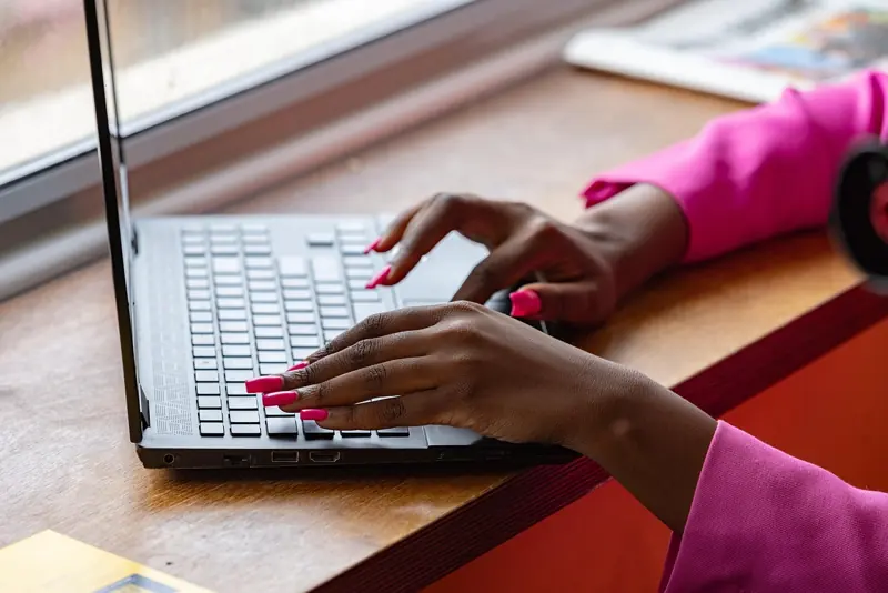 A woman typing on a laptop